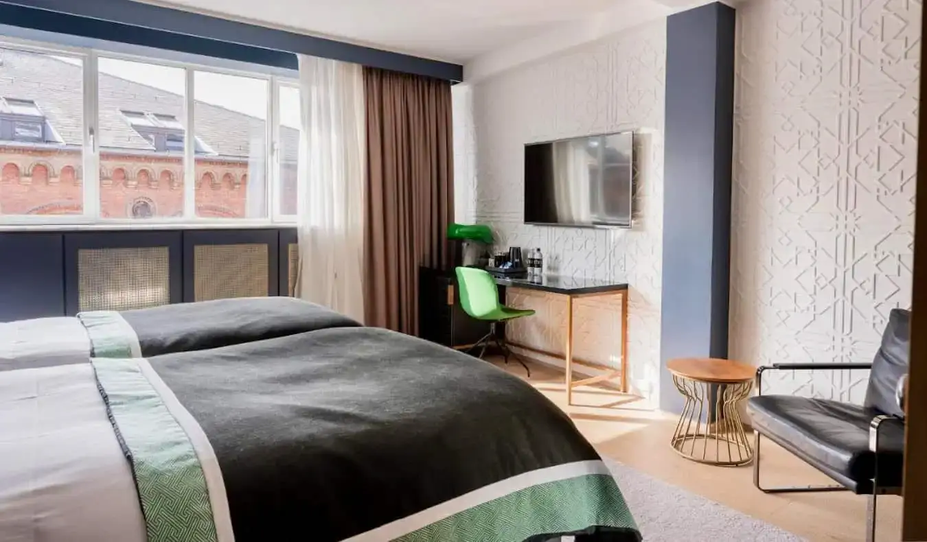 Una elegante habitación de hotel con una cama grande en el Hotel Skt Petri en Copenhague, Dinamarca