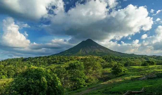 Um vulcão solitário à distância com vista para uma selva exuberante