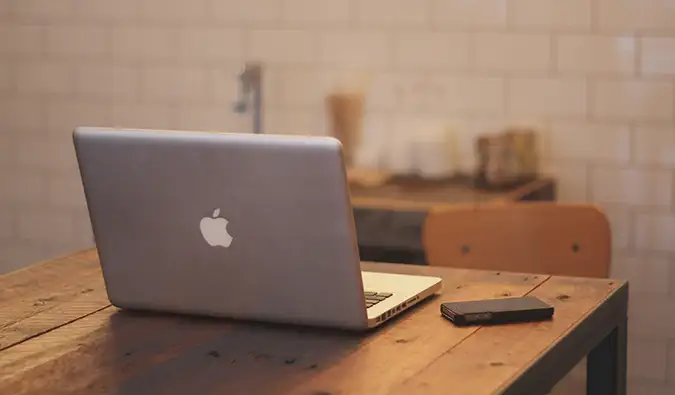 een laptop op een tafel naast een mobiele telefoon