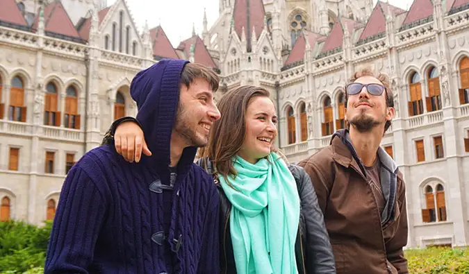 Celinne da Costa ir du jos „Couchsurfing“ šeimininkai vyrai pozuoja nuotraukai Europoje