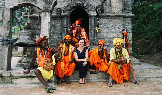 Celinne da Costa pozand la un templu din India cu niste localnici