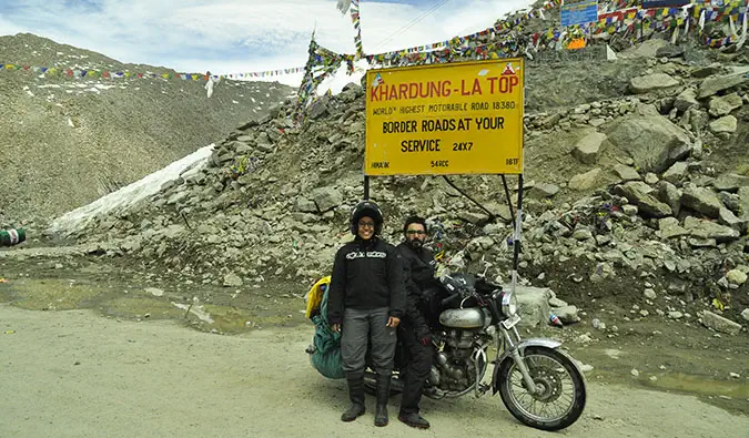 Vikram und Ishwinder von Empty Rusacks posieren auf ihrem Motorrad in der Nähe eines Berges