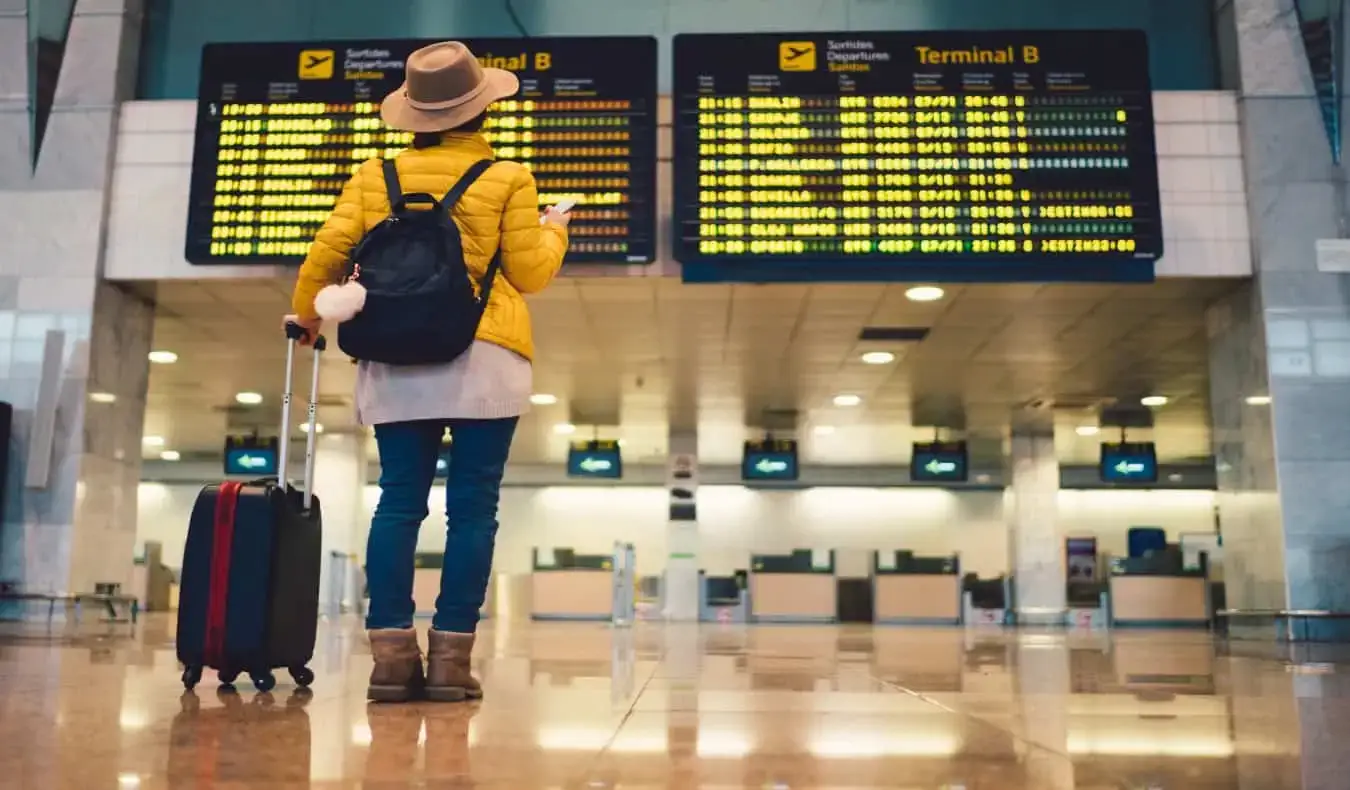 mulher em frente ao painel de embarque no aeroporto de Barcelona