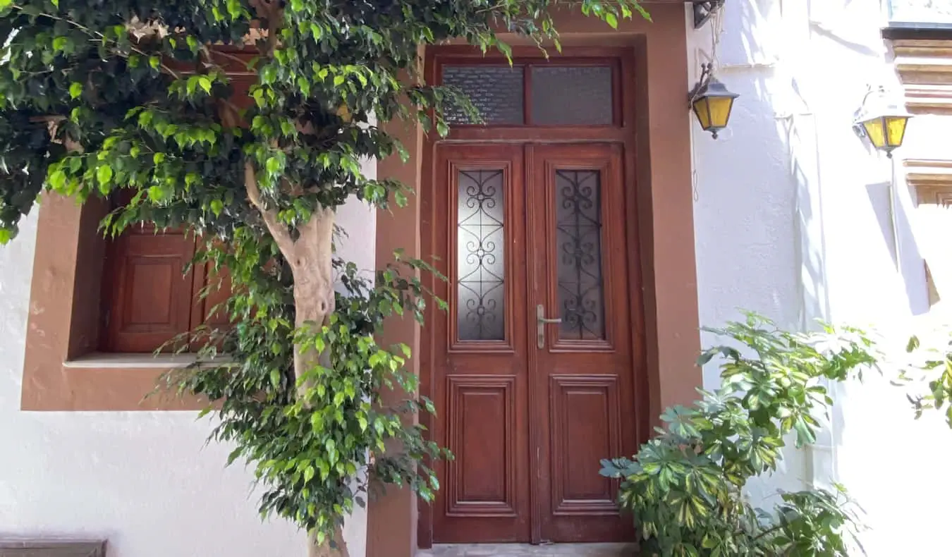 Una porta pintada envoltada de vegetació a Creta, Grècia