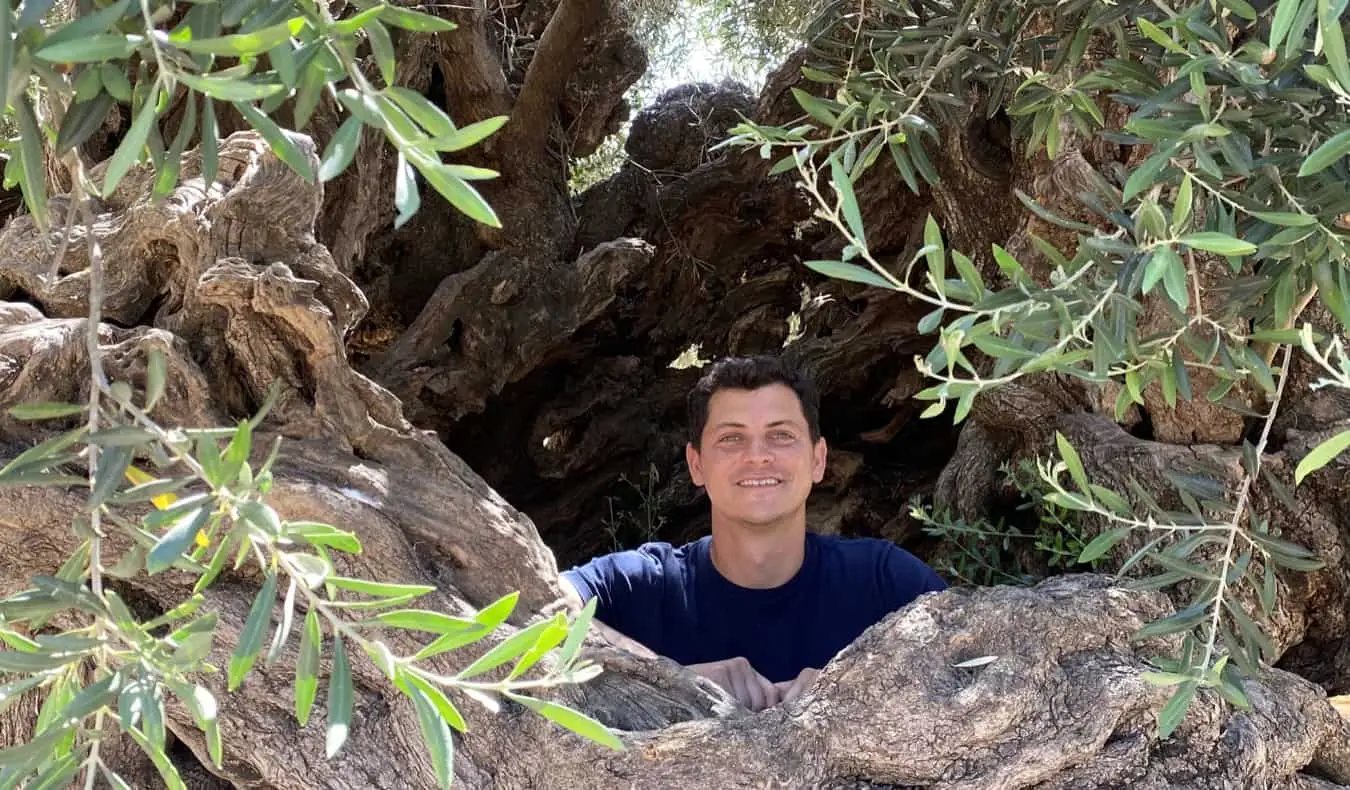 El nómada Matt asomándose a través de un agujero en las rocas de Grecia