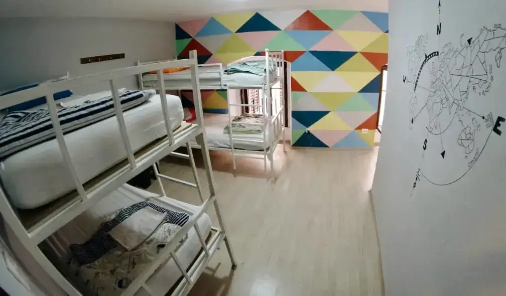 Det indre af en lille sovesal med køjesenge og et kort på væggen i Fiesta Siesta Hostel i Split, Kroatien