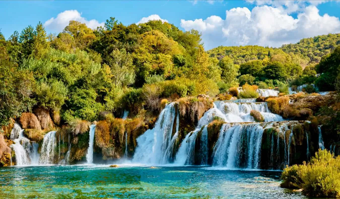 Air terjun Krka yang indah di taman nasional di Kroasia, dikelilingi oleh tanaman hijau subur