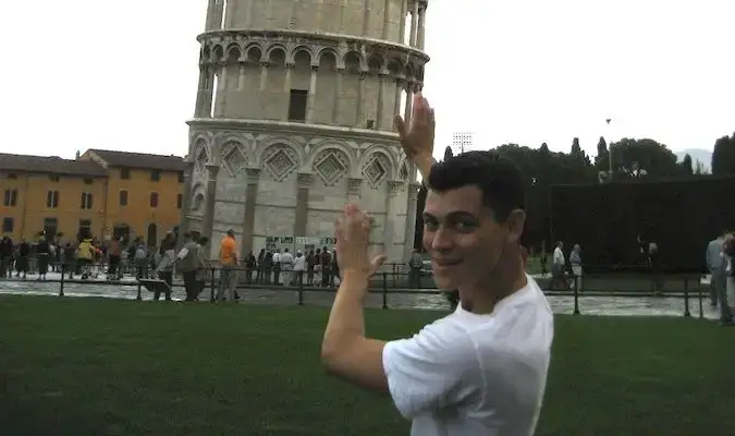 Matt berpura-pura memegang Menara Condong Pisa di Itali