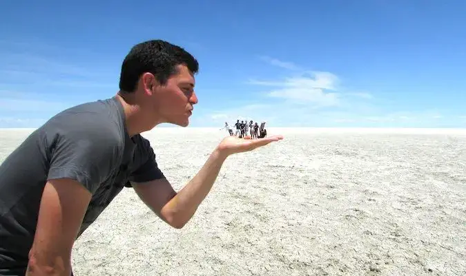 Nomadiske Matt og rejsevenner poserer som en turist på en saltflade