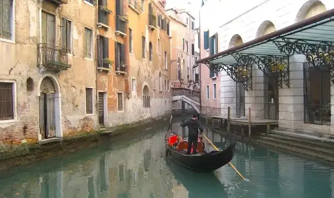 Gondola cantik dengan pelancong di terusan venice, Itali