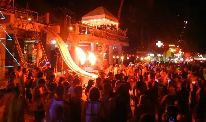 Verrücktes Feuerzeichen und junge Rucksacktouristen in Thailand bei der Full Moon Party