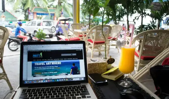 Nomadic Matt bekerja jarak jauh dari laptop di situs web di luar negeri di Kamboja tropis