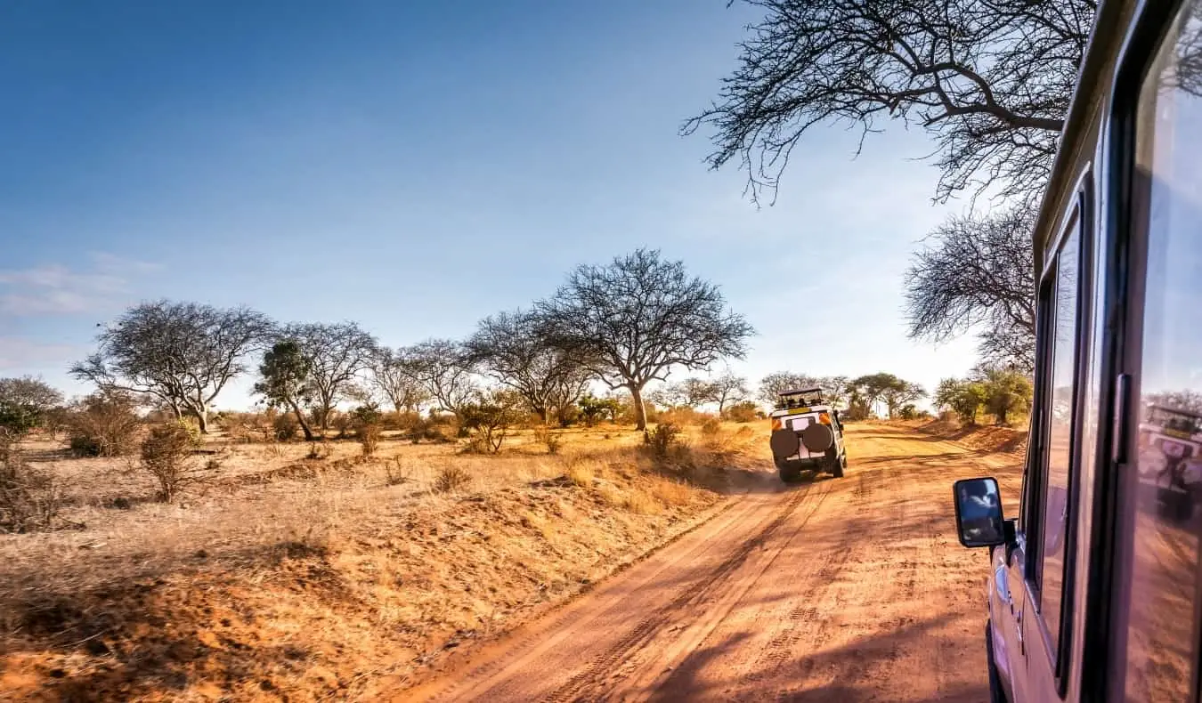 En jeep som kjører ned Kenyas savannesletter mens han er på safari