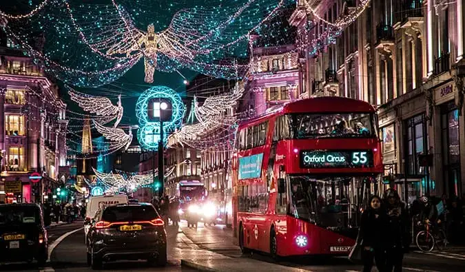 Un autobús rojo de Londres con luces navideñas por la noche.