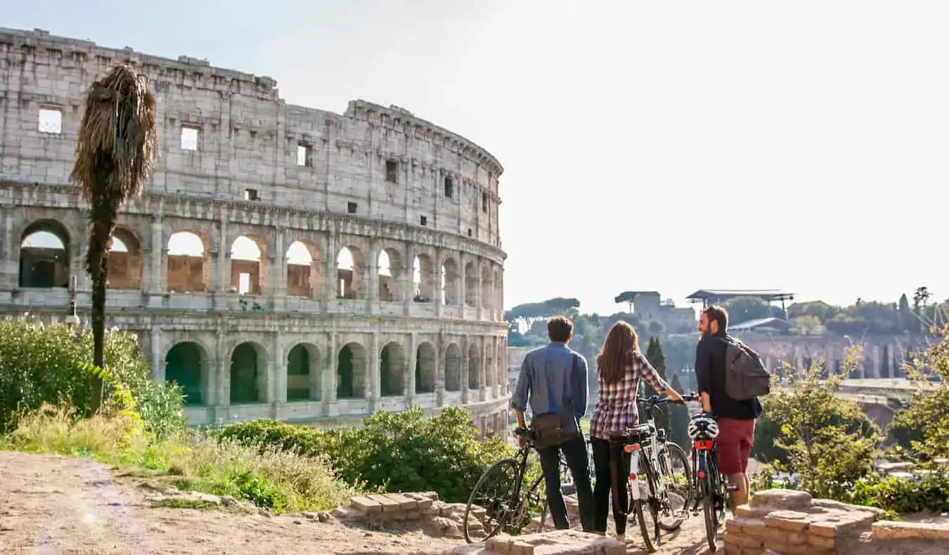 Un grupo de viajeros posando cerca del histórico Coliseo en Roma, Italia