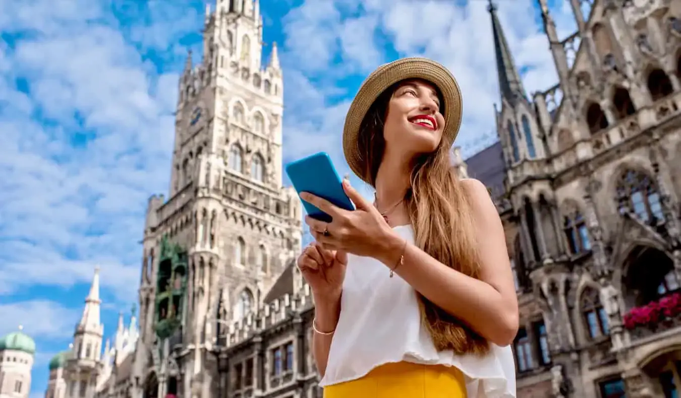 Una mujer que viaja sola usando su eSIM y su teléfono inteligente mientras viaja por Europa