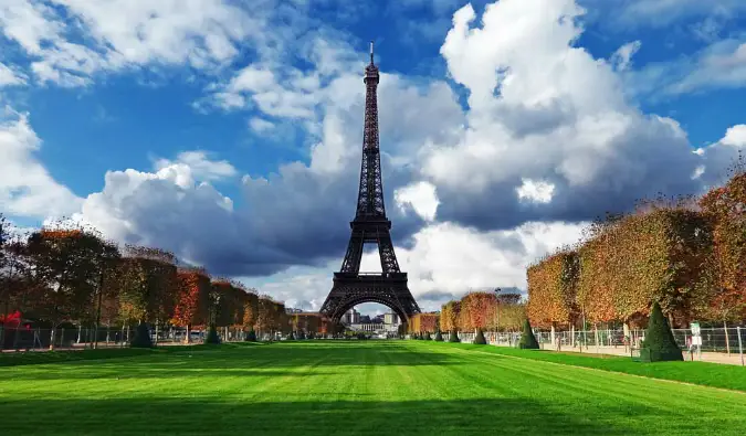 A famosa Torre Eiffel elevando-se em Paris em frente a um grande campo de grama verde