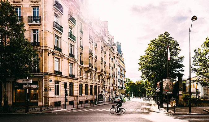 en man som cyklar över en korsning på Paris gator