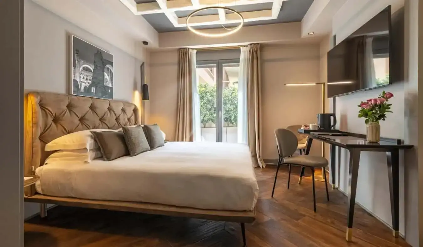 Groot bed, bureau en tv aan de muur in het Loly Boutique Hotel in Rome, Italië