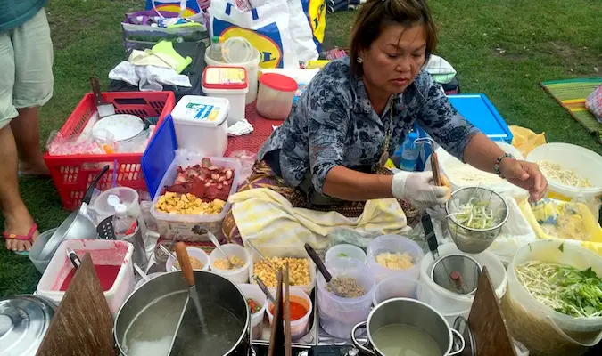 Wanita Thai menghidangkan makanan Thai di pasar di Berlin