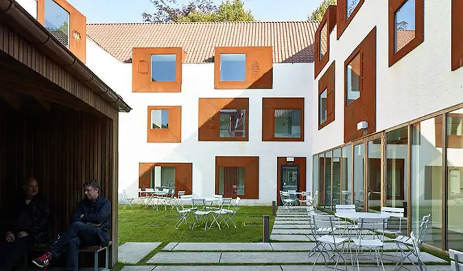 Cour intérieure avec tables et chaises au Snuffel Hostel à Bruges