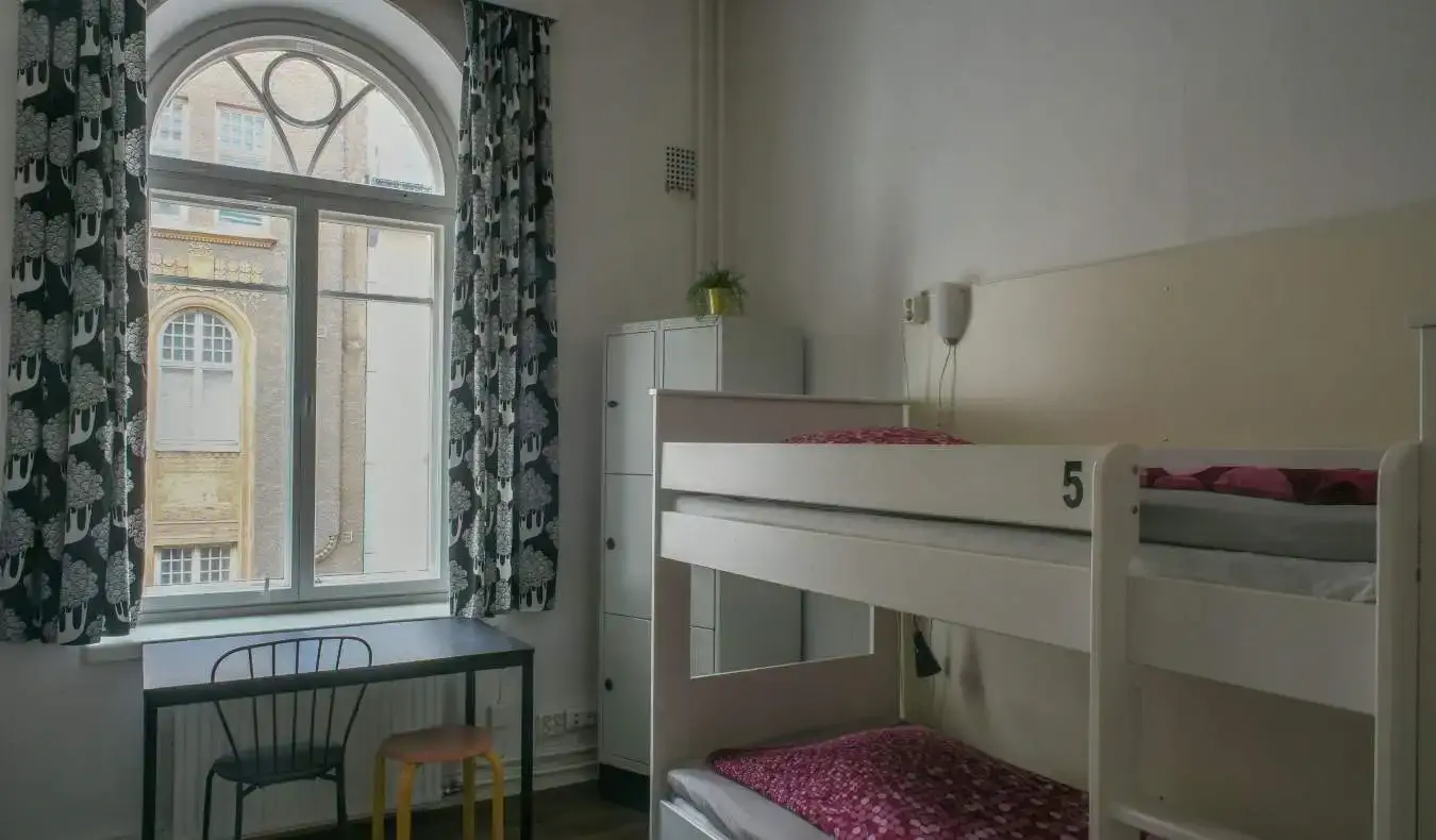 Phòng ký túc xá tại Hostel Diana Park ở Helsinki, Phần Lan, với giường tầng màu trắng và rèm che cửa sổ đón ánh nắng tự nhiên chiếu vào.