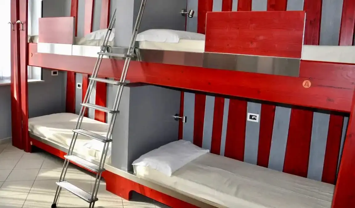 Ang mga pulang bunks sa isang dorm room sa Roma Scout Center hostel sa Rome, Italy