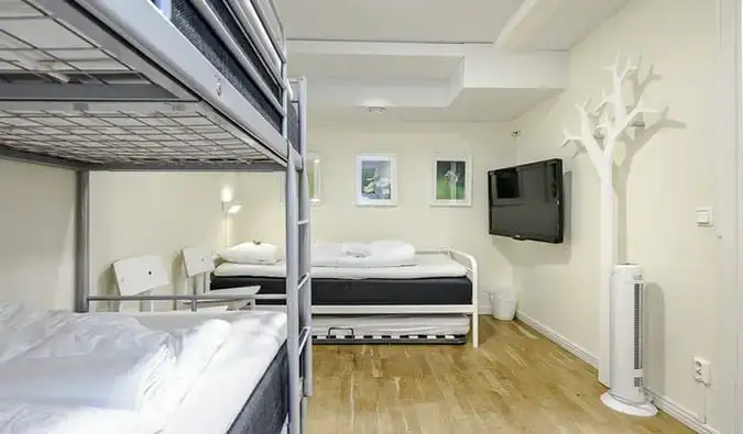 Phòng màu trắng được trang trí tối giản với giường tầng và giường đôi tại City Hostel, Stockholm