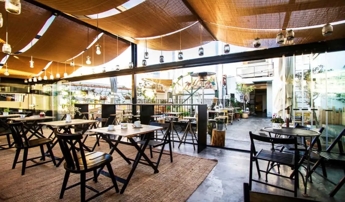 Terrasse sur le toit avec parties couvertes et découvertes, avec chaises et table pour s'asseoir au Hat Hostel à Madrid, Espagne.