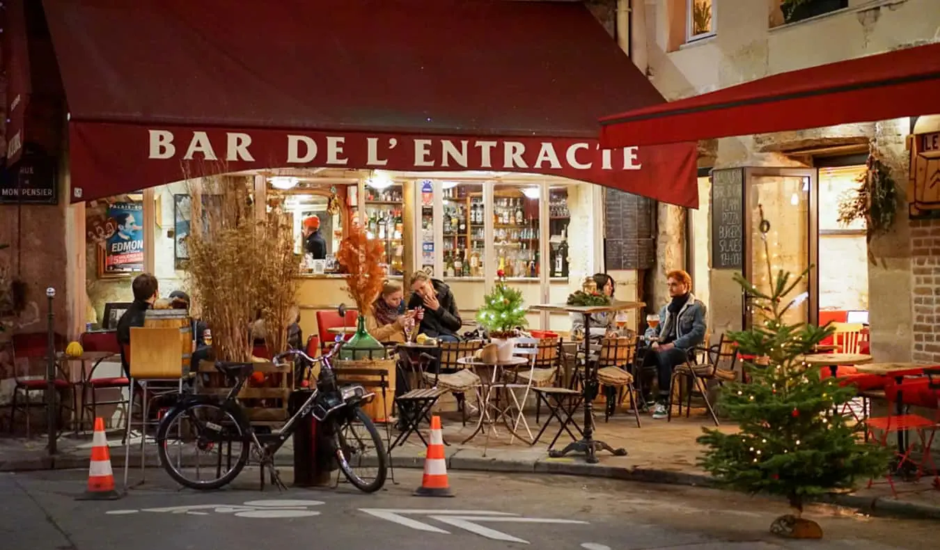 Ein Café in Paris, Frankreich, mit Menschen, die sich draußen auf dem Bürgersteig unterhalten