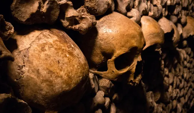 Tulang dan tengkorak lama Catacombs gelap di Paris, Perancis