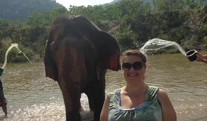 En kvinnlig resenär som badar en elefant i Chiang Mai, Thailand