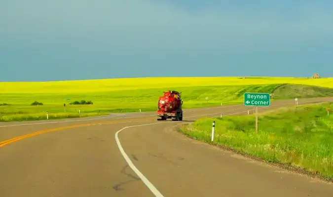 Camion rouge sur une route ouverte avec un champ vert à la campagne