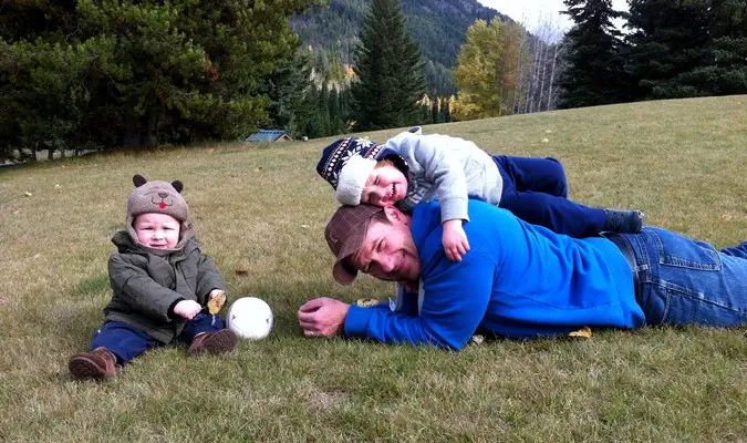 père et fils jouant sur l'herbe pendant leur road trip