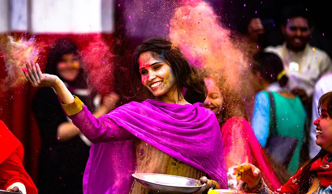 Seorang wanita diwarnakan di Holi di India