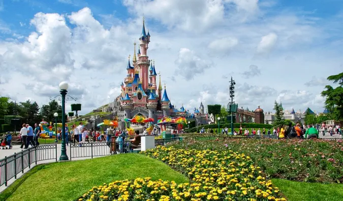 Obrazovo dokonalý zámok v srdci Disneylandu v Paríži obklopený kvetmi vo Francúzsku