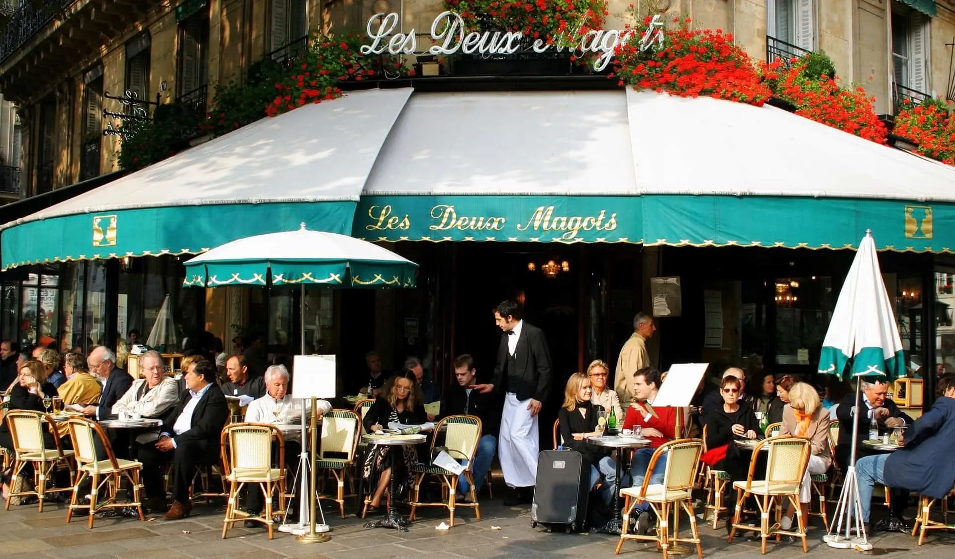 السكان المحليون والسياح يسترخون في Les Deux Magots في باريس، فرنسا