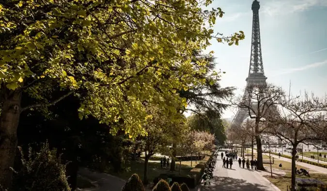 Berjalan menyusuri laluan yang dikelilingi oleh pokok berhampiran Menara Eiffel di Paris, Perancis