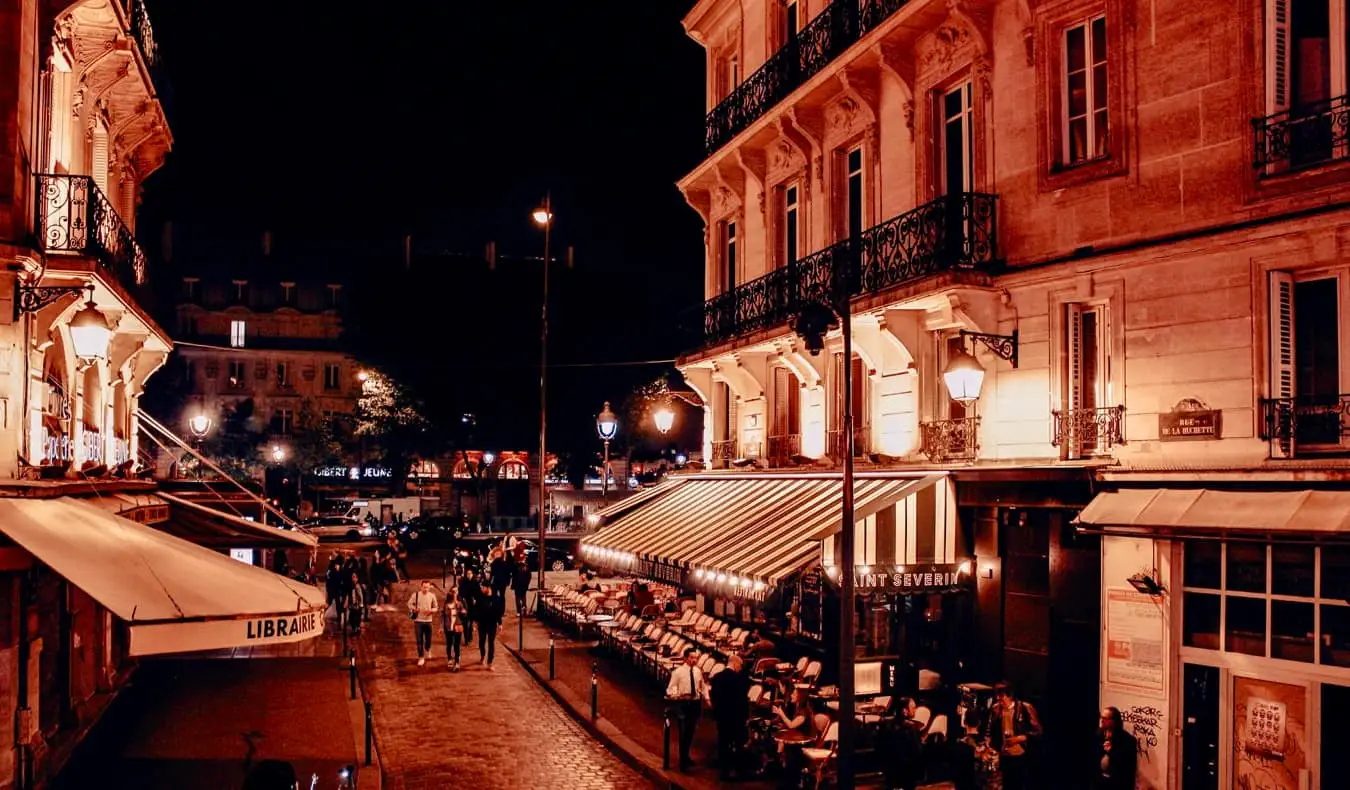 O pátio de um bar movimentado em uma noite em Paris, França