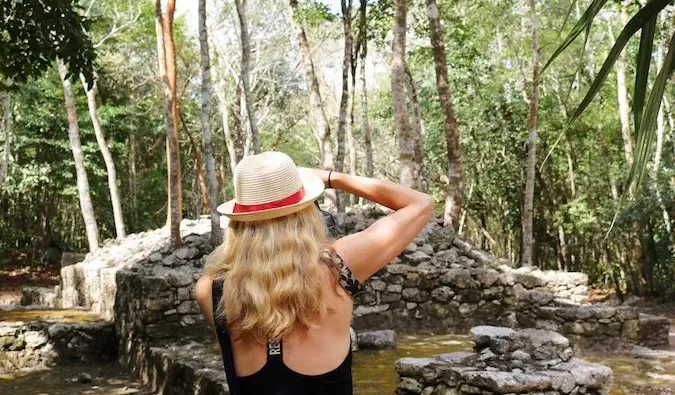 Seorang pelancong wanita solo mengambil foto di hutan