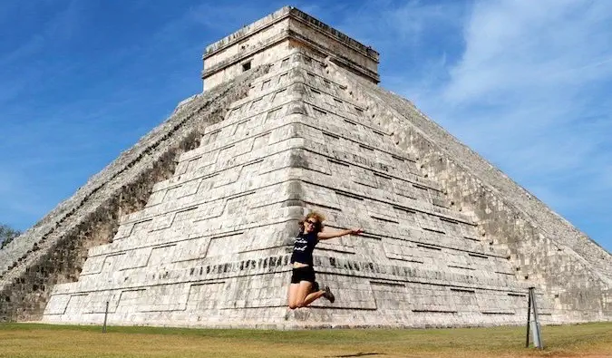 Seorang wanita yang mengunjungi Chichen Itza, Meksiko melompat ke udara untuk berfoto