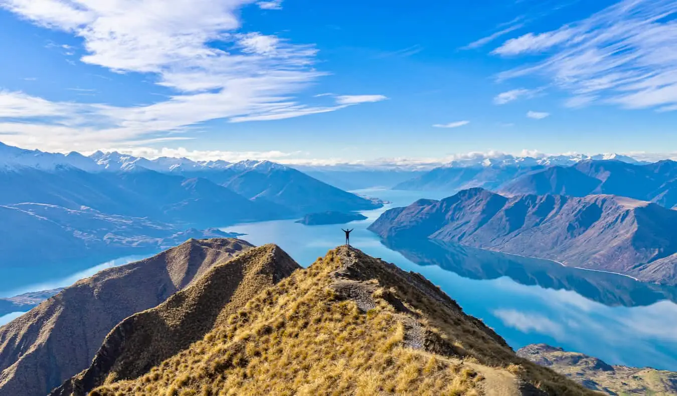 Isang solong hiker na umaakyat sa mga burol sa magandang New Zealand sa isang magandang araw