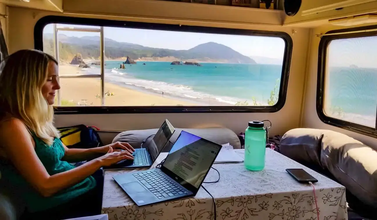 Anne von HoneyTrek arbeitet in ihrem Wohnmobil an einem Laptop