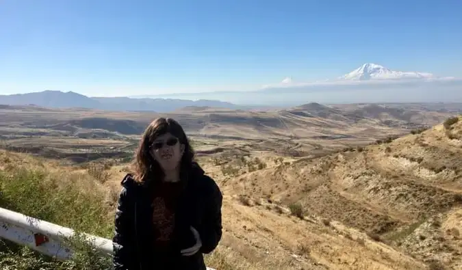 Staci debout près d’une grande montagne