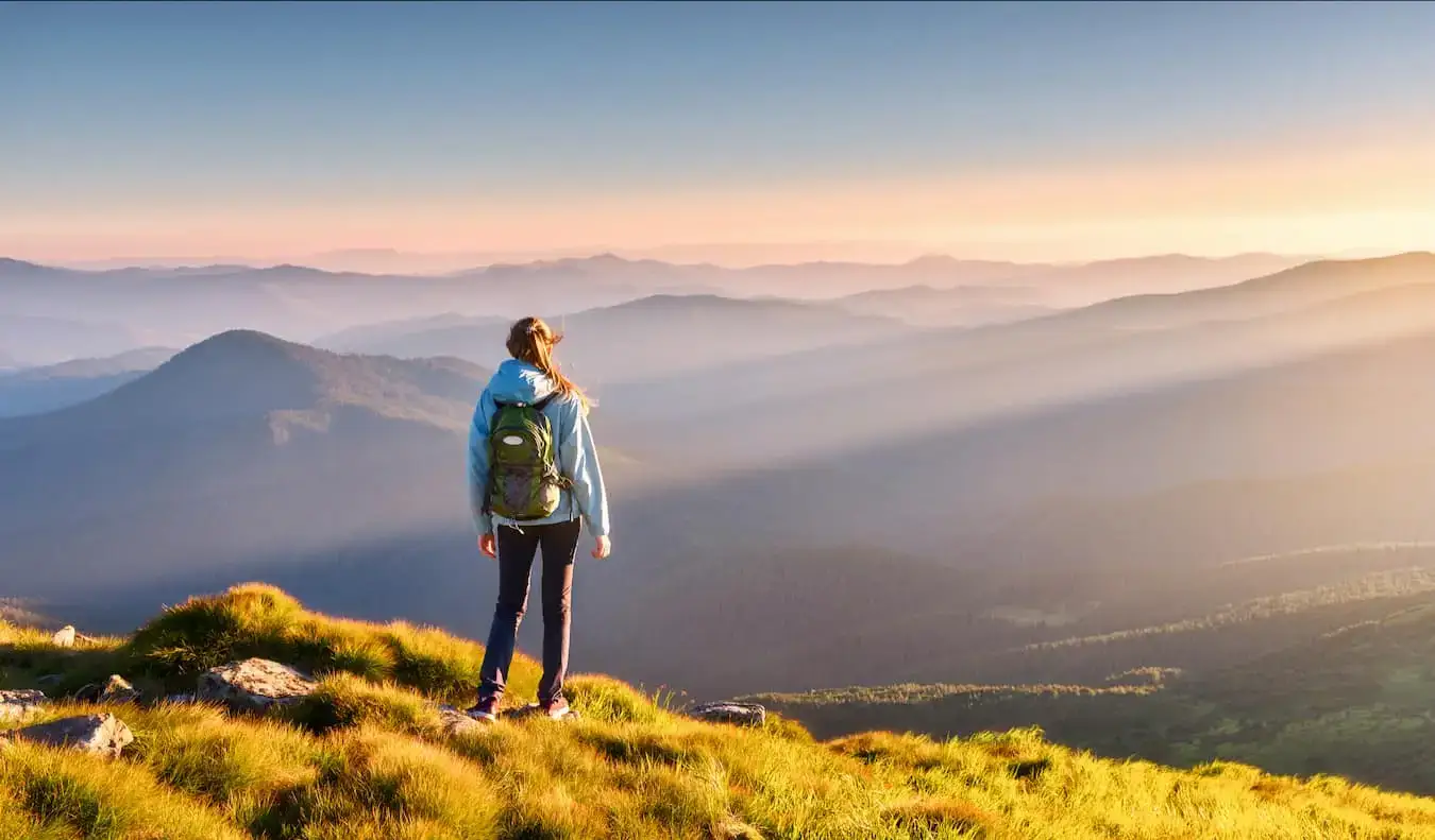 Une voyageuse seule en randonnée dans les collines au coucher du soleil