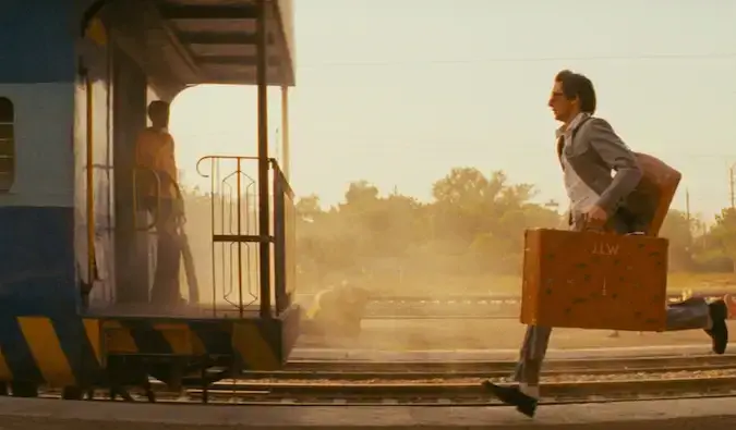 Hombre corriendo detrás de un tren en la película India llamada Darjeeling Limited.