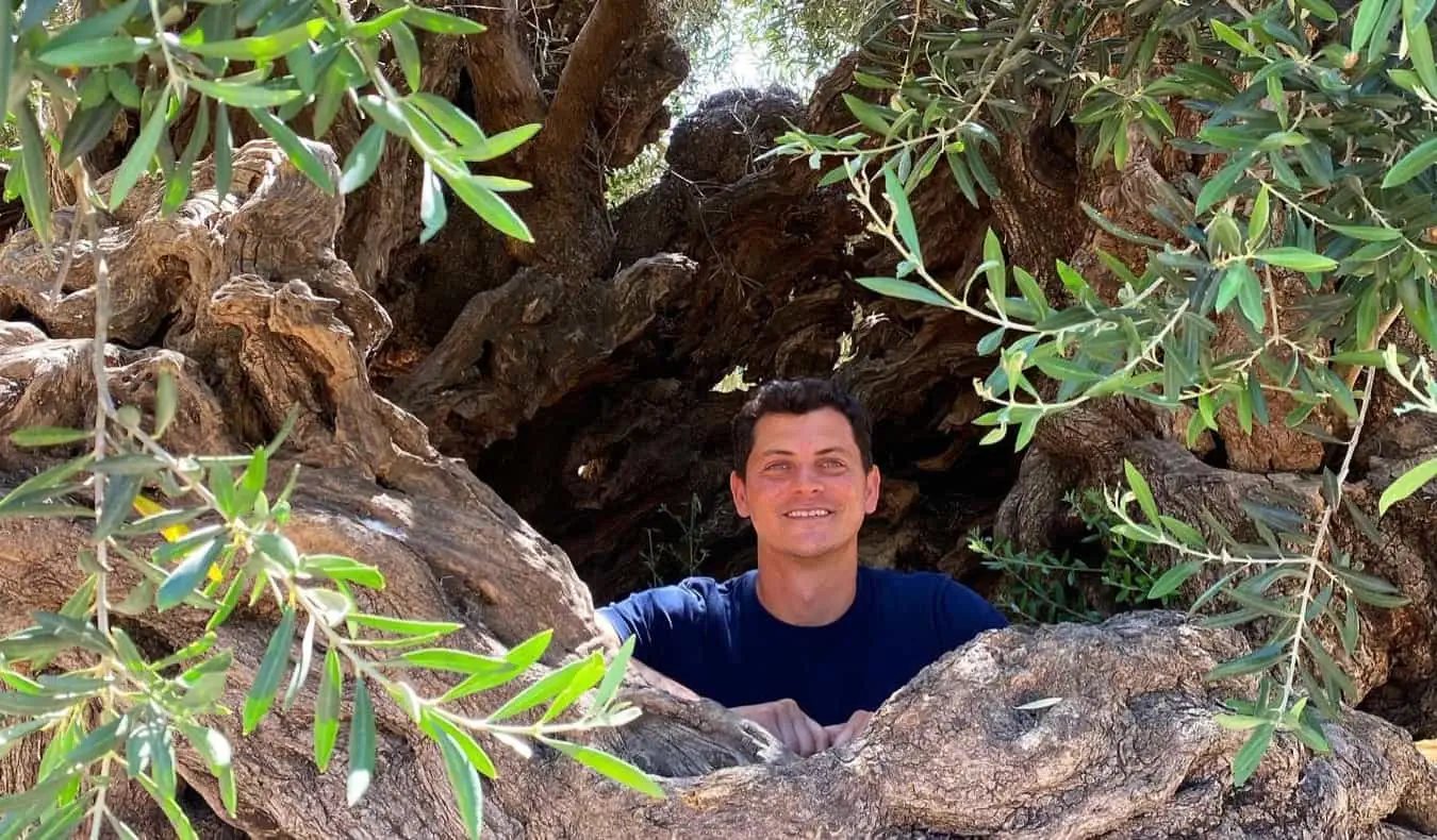 Nômade Matt posando em um grande buraco na floresta enquanto caminhava nos Bálcãs