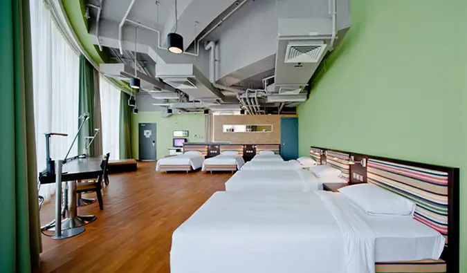 Kamar asrama yang besar dan luas dengan tempat tidur ganda, tempat tidur kembar, dan meja panjang di Y Loft, Hong Kong