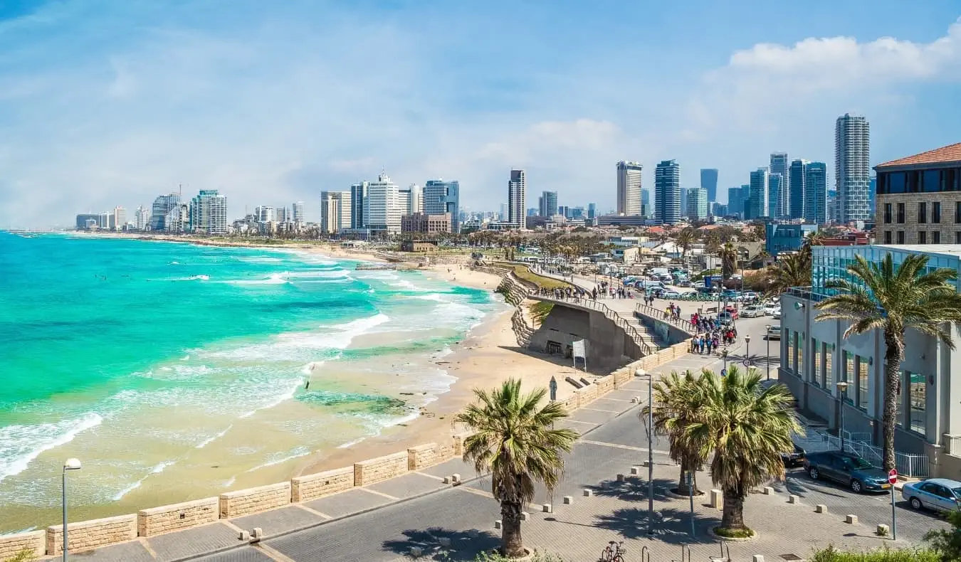 O horizonte da cidade de Tel Aviv, Israel, com uma praia em forma de ferradura, o oceano azul celeste e arranha-céus ao fundo