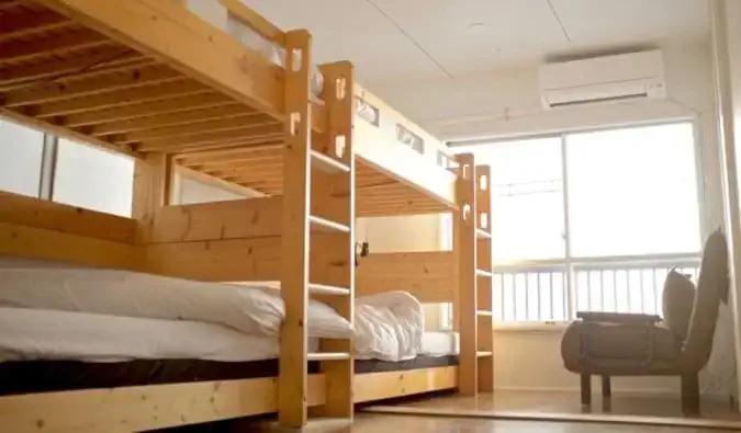 Houten stapelbedden in een slaapzaal in Hostel Chapter Two in Tokio, Japan